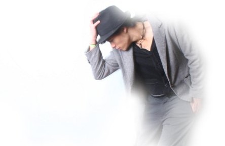 Person posing in suit and hat.